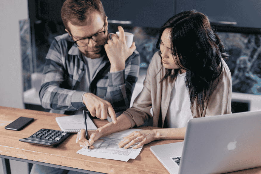 Casal analisando contas e orçamento em casa para renegociar dívidas e conseguir condições melhores com credores.