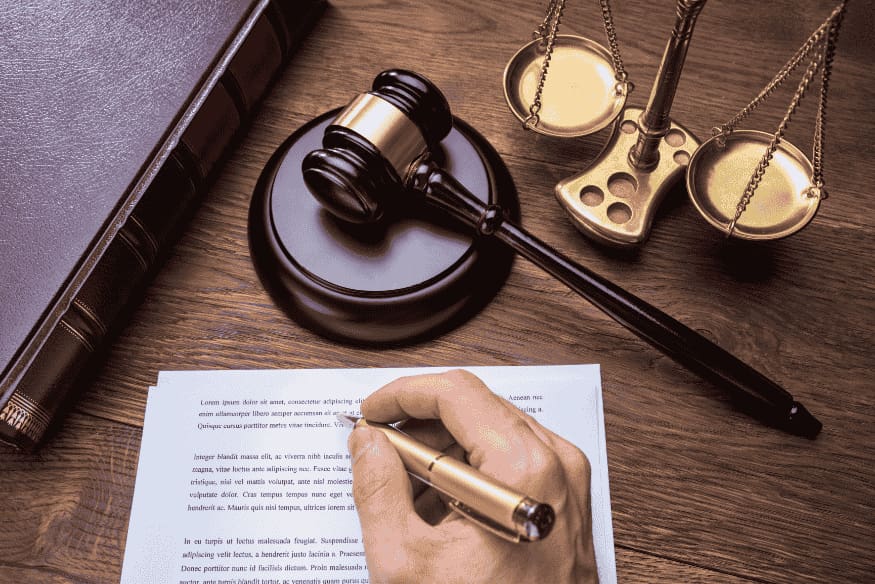Mesa com martelo do juiz, balança da justiça e documento sendo assinado, representando a prescrição de dívidas e os cuidados legais no Brasil.